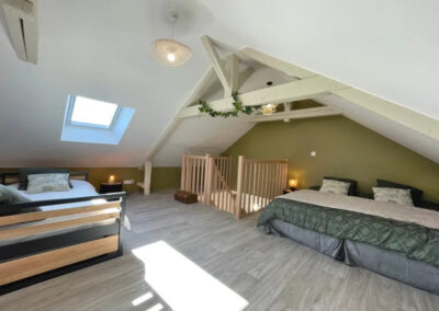 Intérieur du Gîte communal de la Pierre Procureuse à Gémages - Chambre sous les combles avec plusieurs lits